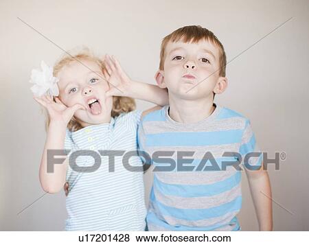 Stock Photo - Studio Shot, Portrait of girl and boy making faces. Fotosearch
