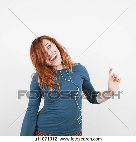 Studio shot, Portrait of smiling woman listening to music View Large Photo Image Stock Image - Studio shot, Portrait of smiling woman listening to music. Fotosearch