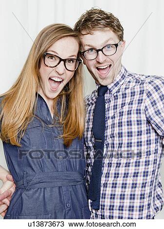 Stock Image - Studio Shot, portrait of young couple smiling. Fotosearch
