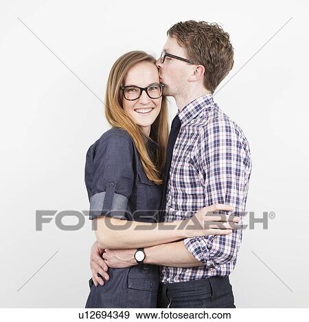 Stock Photo - Studio Shot, portrait of young couple embracing. Fotosearch