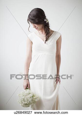Studio Shot, Portrait of young woman holding white flowers View Large Photo Image Stock Photo - Studio Shot, Portrait of young woman holding white flowers. Fotosearch