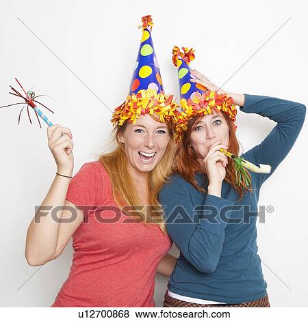 Studio Shot, Two young women wearing party hats View Large Photo Image Stock Photo - Studio Shot, Two young women wearing party hats. Fotosearch