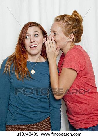 Studio Shot, Young women whispering in friend's ear View Large Photo Image Stock Photography - Studio Shot, Young women whispering in friend's ear. Fotosearch