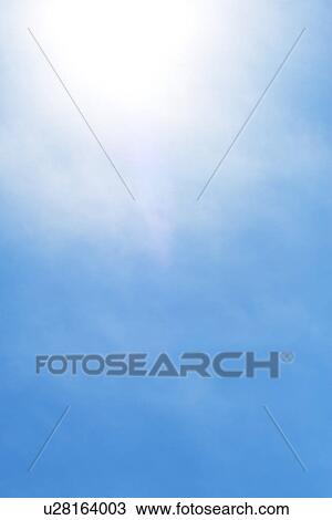 Stock Image - Sun behind small cloud on blue sky. Fotosearch