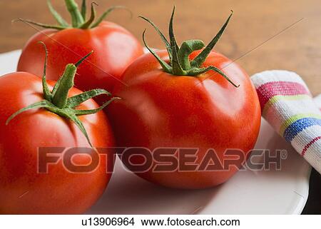Tomatoes on plate, studio shot View Large Photo Image Picture - Tomatoes on plate, studio shot. Fotosearch