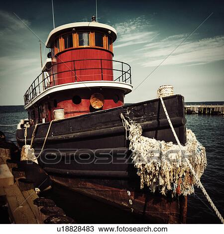 Stock Image - Tugboat moored at pier. Fotosearch