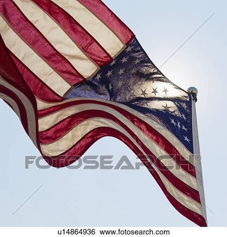 Stock Photograph - US flag against blue sky. Fotosearch