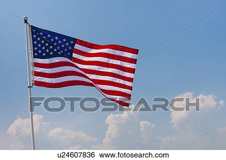 Stock Photograph - US flag against blue sky. Fotosearch