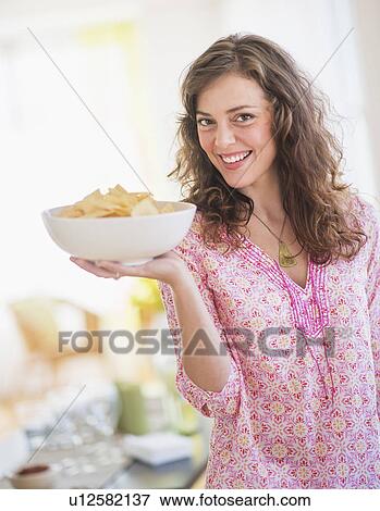 Stock Photo - Woman carrying bowl with snacks. Fotosearch