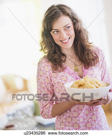 Stock Photograph - Woman carrying bowl with snacks. Fotosearch