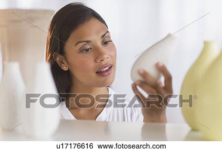 Stock Photograph - Woman choosing vase. Fotosearch