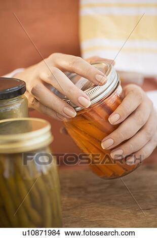 Woman closing jar with pickled vegetables View Large Photo Image Picture - Woman closing jar with pickled vegetables. Fotosearch