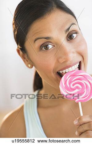 Stock Image - Woman eating lollypop. Fotosearch