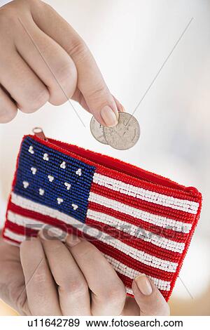 Stock Photo - Woman holding coins and purse with american flag on it. Fotosearch