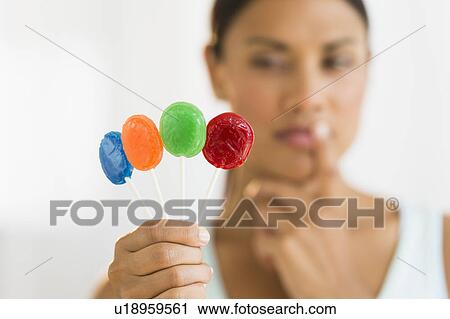 Woman holding colorful lollypops View Large Photo Image Stock Image - Woman holding colorful lollypops. Fotosearch