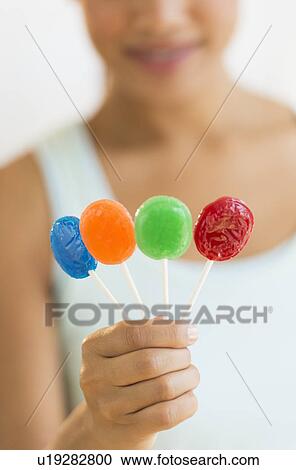 Woman holding colorful lollypops View Large Photo Image Stock Image - Woman holding colorful lollypops. Fotosearch