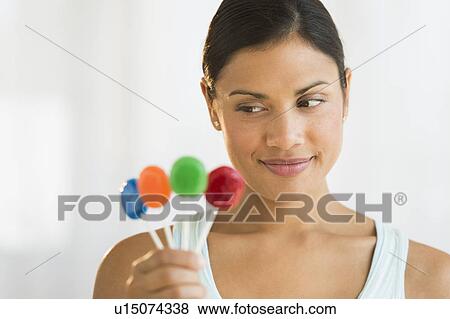 Stock Photo - Woman holding colorful lollypops. Fotosearch