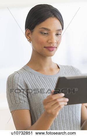 Stock Image - Woman holding digital tablet. Fotosearch
