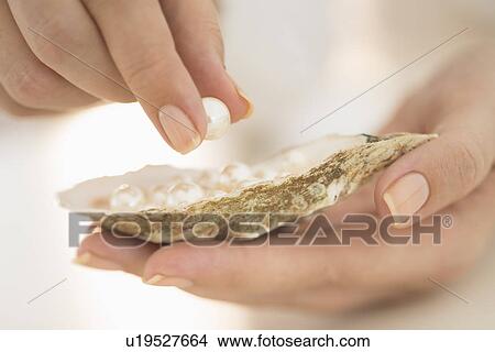 Woman holding shell and pearl View Large Photo Image Picture - Woman holding shell and pearl. Fotosearch