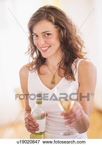 Woman holding wine bottle and glass View Large Photo Image Stock Photo - Woman holding wine bottle and glass. Fotosearch