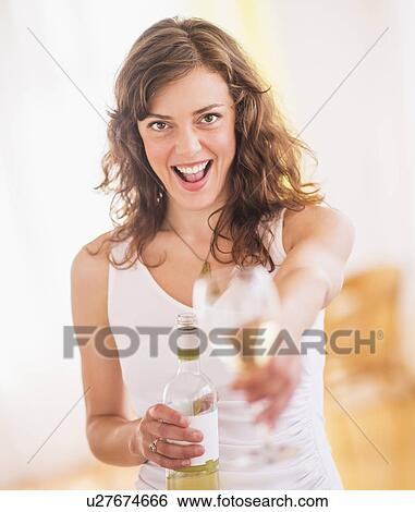 Woman holding wine bottle and glass View Large Photo Image Stock Photograph - Woman holding wine bottle and glass. Fotosearch