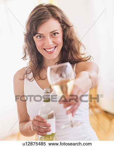 Stock Photography - Woman holding wine bottle and glass. Fotosearch