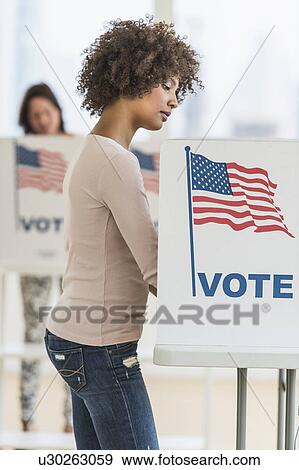 Stock Photo - Woman in voting booth. Fotosearch