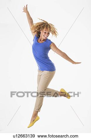 Stock Photo - Woman jumping, studio shot. Fotosearch