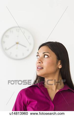 Woman looking at clock on wall View Large Photo Image Stock Image - Woman looking at clock on wall. Fotosearch