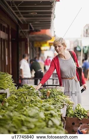 Woman looking at fresh vegetables at street market View Large Photo Image Stock Image - Woman looking at fresh vegetables at street market. Fotosearch