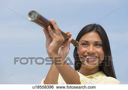 Woman looking through telescope View Large Photo Image Stock Photograph - Woman looking through telescope. Fotosearch