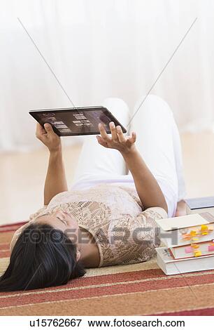 Woman lying on floor and using tablet PC View Large Photo Image Stock Photo - Woman lying on floor and using tablet PC. Fotosearch