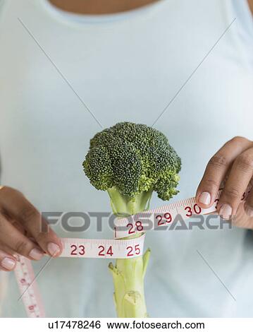 Woman measuring broccoli View Large Photo Image Stock Photograph - Woman measuring broccoli . Fotosearch