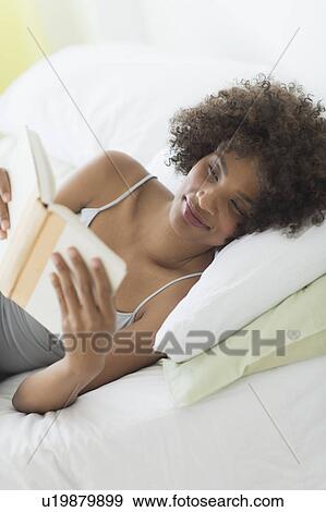 Woman reading in bed View Large Photo Image Stock Photo - Woman reading in bed. Fotosearch