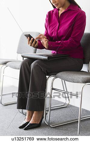 Woman sitting in waiting room and text messaging View Large Photo Image Stock Photo - Woman sitting in waiting room and text messaging. Fotosearch
