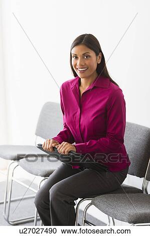 Stock Image - Woman sitting in waiting room. Fotosearch