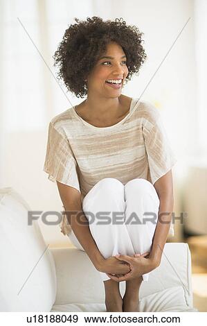 Woman sitting on sofa View Large Photo Image Stock Photo - Woman sitting on sofa. Fotosearch