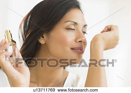 Stock Photo - Woman smelling perfume on wrist. Fotosearch