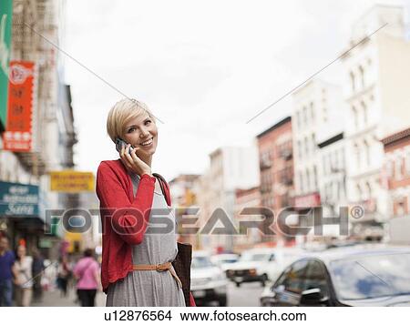 Woman smiling and talking on phone View Large Photo Image Picture - Woman smiling and talking on phone. Fotosearch