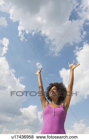 Woman stretching under blue sky View Large Photo Image Stock Photo - Woman stretching under blue sky. Fotosearch