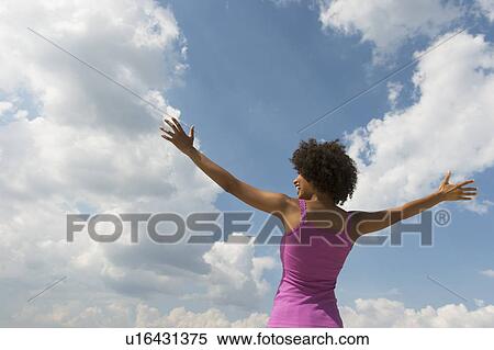 Woman stretching under blue sky View Large Photo Image Stock Photography - Woman stretching under blue sky. Fotosearch