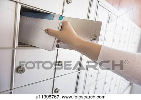Stock Photo - Woman taking letters from safety deposit box. Fotosearch
