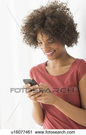 Woman using cell phone, studio shot View Large Photo Image Stock Image - Woman using cell phone, studio shot. Fotosearch