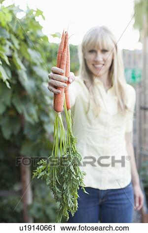 Stock Image - Woman working in garden. Fotosearch