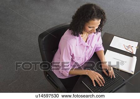 Stock Image - Woman working in office. Fotosearch
