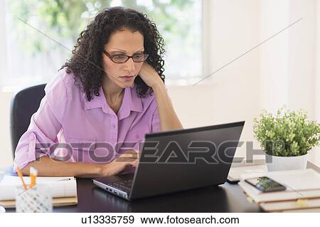 Stock Photo - Woman working in office. Fotosearch