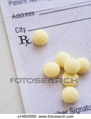 Stock Image - Yellow pills with prescription form, studio shot. Fotosearch