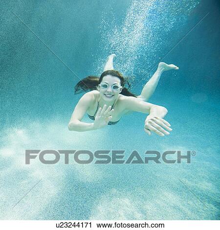Young attractive woman diving in swimming pool View Large Photo Image Stock Image - Young attractive woman diving in swimming pool. Fotosearch