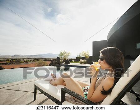 Young attractive woman enjoying cocktail by swimming pool View Large Photo Image Stock Photo - Young attractive woman enjoying cocktail by swimming pool. Fotosearch