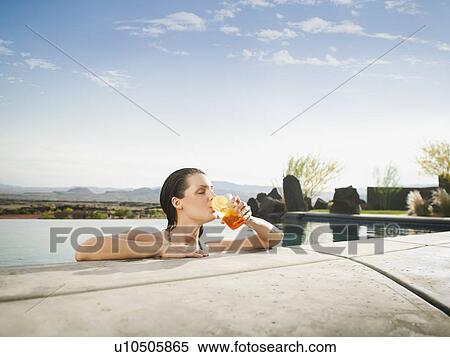 Young attractive woman enjoying cocktail on edge of swimming pool View Large Photo Image Stock Photography - Young attractive woman enjoying cocktail on edge of swimming pool. Fotosearch
